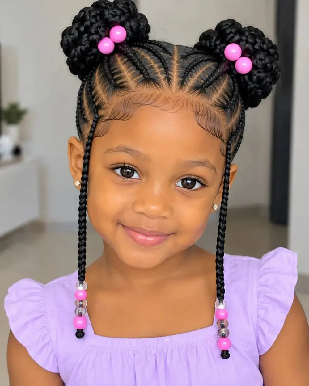 Little girl with braided space buns and pink beads